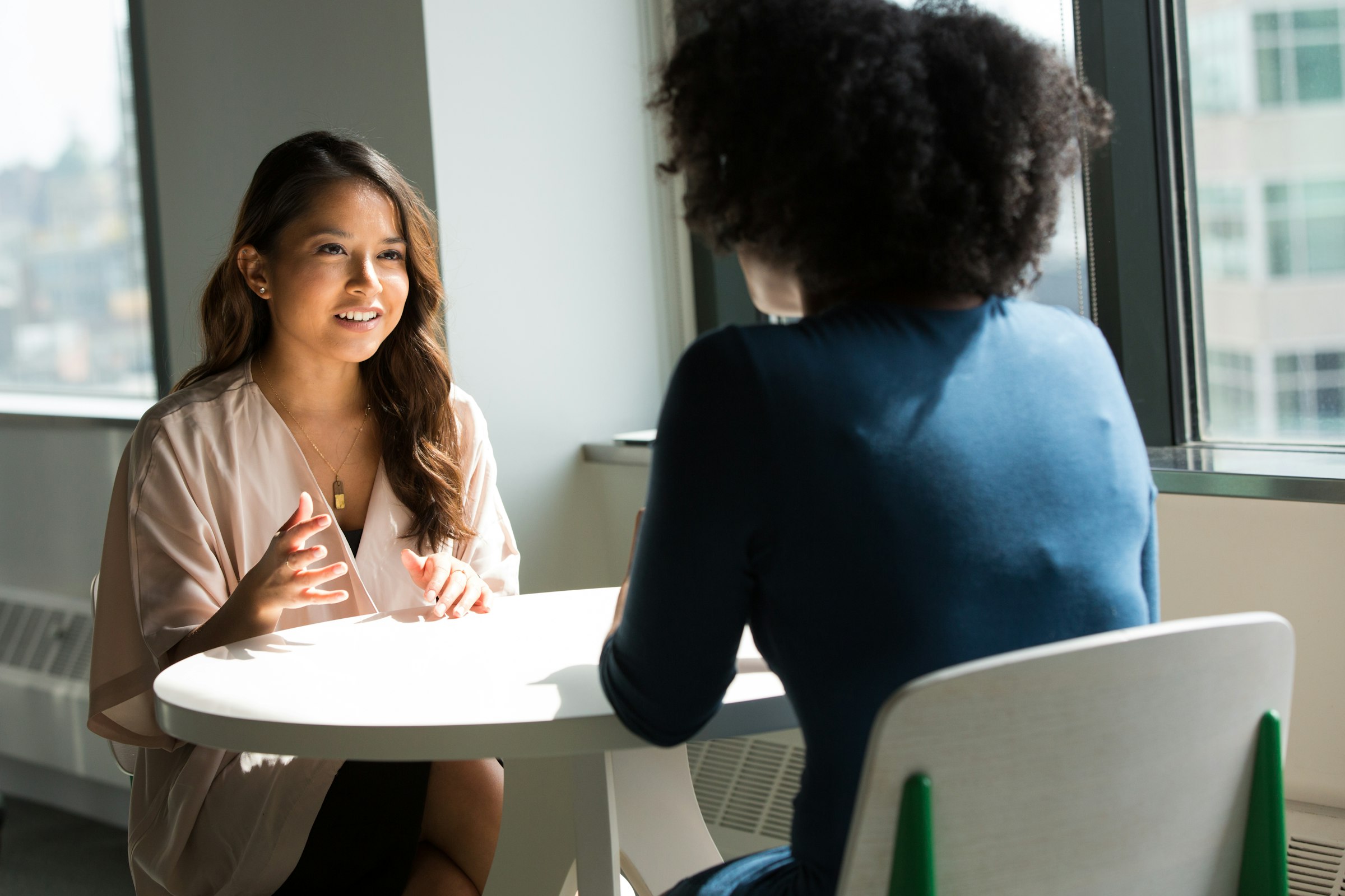 A staff member and a student talking one-on-one at a table